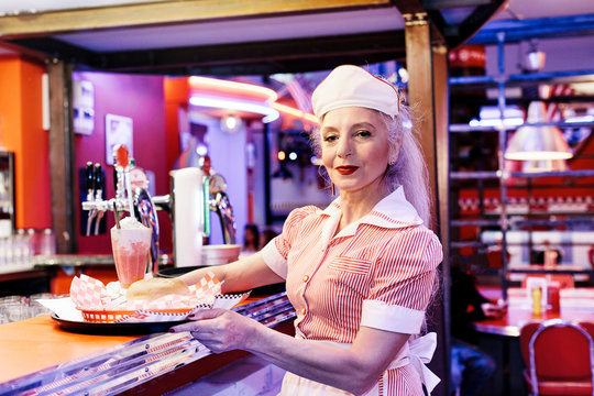 Portrait of mature female waitress in 1950's diner