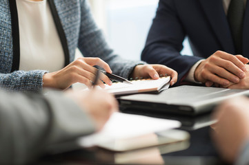 Cropped shot of businesswoman and man making notes in office meeting