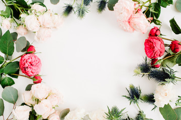 Round frame wreath made of red and beige rose flowers, eringium flower, eucalyptus branches and leaves on white background. Flat lay, top view. Floral background