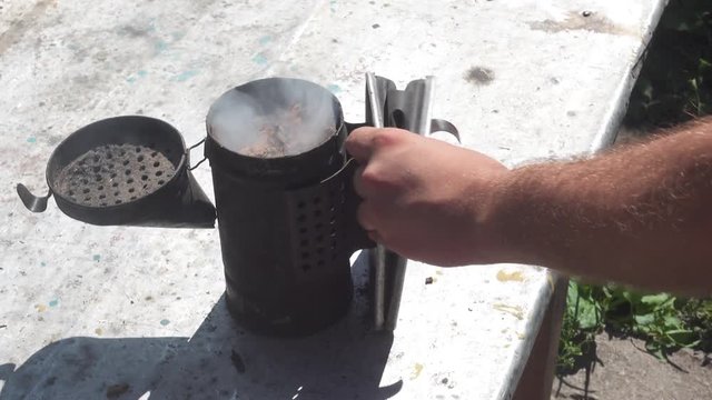 Open and smoke bee smoker. Beekeeping tools. Cllose up top view footage.