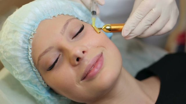 Close-up of young woman having a botox injection at beauty salon. Beautician does a Botox injection on face girl.