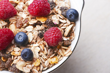 Close-up of breakfast cereal with raspberries and blueberries. Copy space.