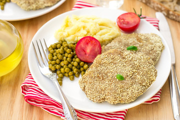 Schnitzel from beef served with mashed potatoes and green beans