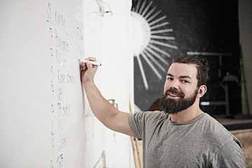 Fitness instructor writing on whiteboard in cross training gym
