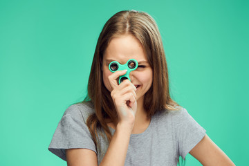 Beautiful young woman on a green background holds a spinner