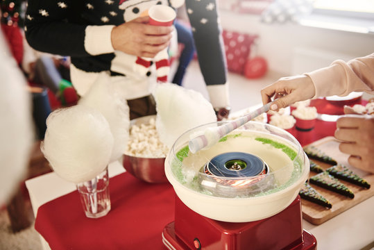 Cropped shot of young woman preparing candyfloss at christmas party