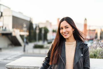 Korean young woman close-up looking at the camera smiling and happy enjoying the views