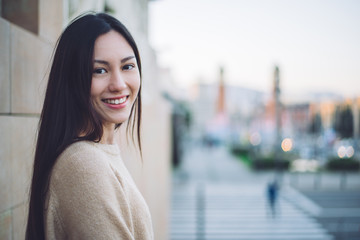 Korean young woman close-up looking at the camera smiling and happy enjoying the views