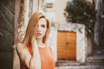 Naklejka premium Outdoor close up portrait of model woman in fashionable red dress.City lifestyle.City lifestyle.Female fashion concept.Retro and vintage filter and colors effect used.