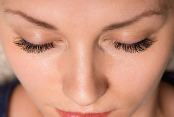 Close-up face of beautiful young woman with beautiful big eyelashes and eyebrows. Macro of human...