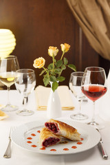 Cherry pie slice arranged on a plate, Wineglass in background, Traditional dessert in elegant setting, Selective focus with soft light