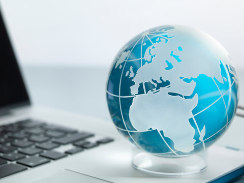 Globe and laptop on desk
