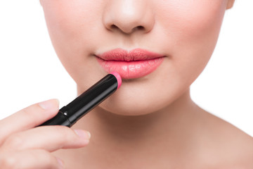 Beautiful young asian woman applying pink lipstick