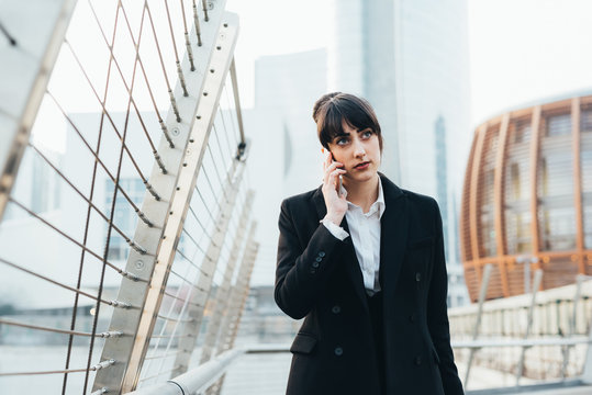 Businesswoman on pedestrian bridge, Milan, Italy