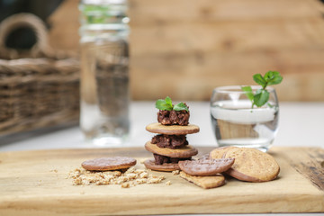 wholewheat and chocolate buscuits stacked with chocolate nut butter and minted water