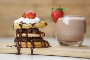 Chocolate smoothie with pancakes, cream and strawberries