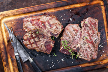 Two Barbecue dry aged Wagyu Porterhouse Steaks as close-up on a cutting board