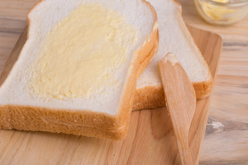 Slices bread with butter on wooden table