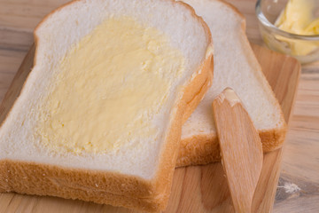 Slices bread with butter on wooden table