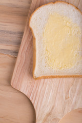 Slices bread with butter on wooden table