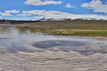 Hot steam coming from the boiling water in the central Iceland in the geothermal area of Hveravellir as a symbol of powerful geothermal green energ