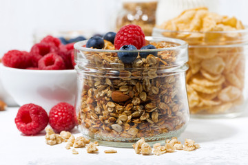 healthy products for breakfast, granola and fresh berries on white table, closeup