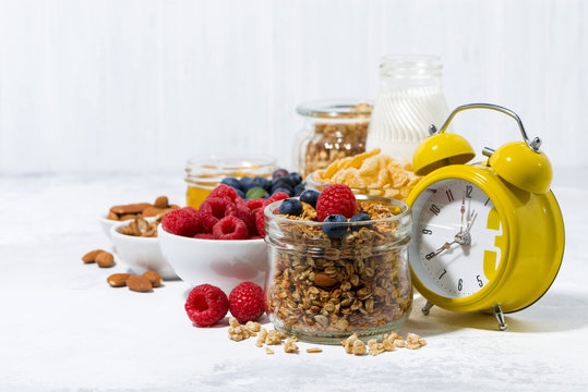 healthy products for breakfast, granola and berries on white background