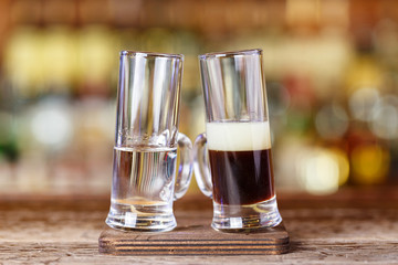Cocktail shot is drunk from two glasses