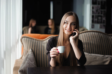 businesswoman talking on phone in a coffee shop