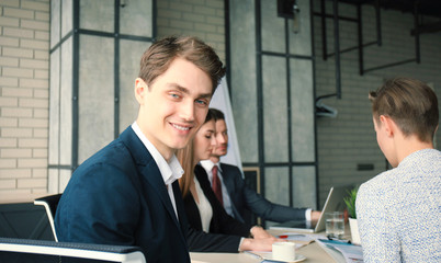 Businessman with colleagues in the background in office.