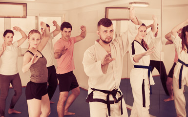 Young adult trainees practicing in karate class