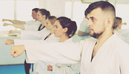 Fototapeta premium Adults trying new martial moves at karate class