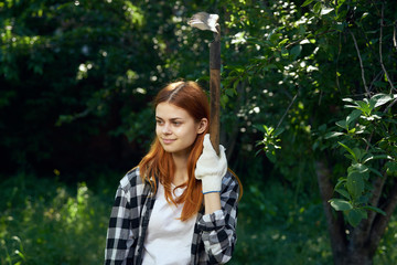 Beautiful young woman running in summer in the garden, gardener