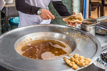Turkish style chopped mussels (Midye tava)  fried in deep oil  in a  special pan on the Street in Istanbul, Turkey.