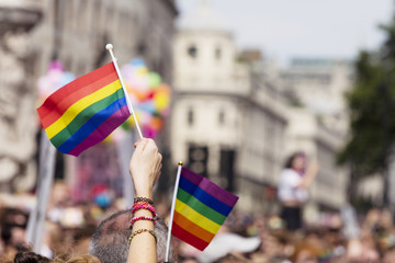 A spectator waves a gay rainbow flag at an LGBT gay pride march in London