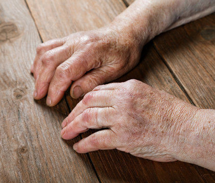 Hands of an old woman close-up on a table