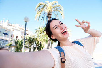 Selfie of happy fun woman with peace sign smiling