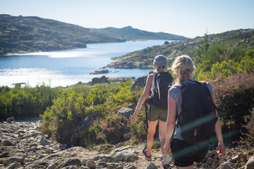 Young women on trip in summer countryside, Tourists in park, Two active women in nature, Girls with backpacks camp near water, European women at lake