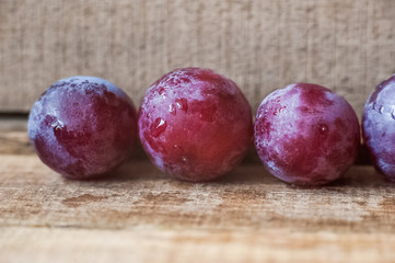 Blue grapes lie on a wooden background. Grapes macro. Grapes with droplets of water. Grapes in a cut. Grapes and wine corks. Blue and green grapes