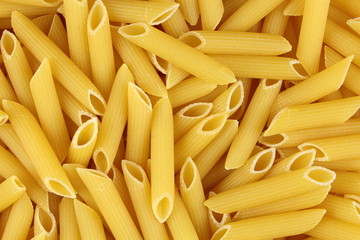 uncooked penne rigate pasta closeup food background texture