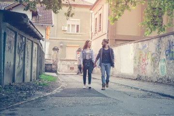 Fototapeta na wymiar Couple holding hands outdoors. Young couple waling on the street.