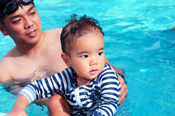 プールで遊ぶ赤ちゃんとお父さん