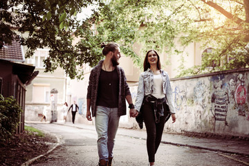 Couple holding hands outdoors. Young couple waling on the street.