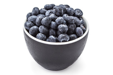 Fresh ripe organic blueberries in a frozen black bowl on a white background