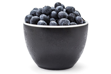Fresh ripe organic blueberries in a frozen black bowl on a white background
