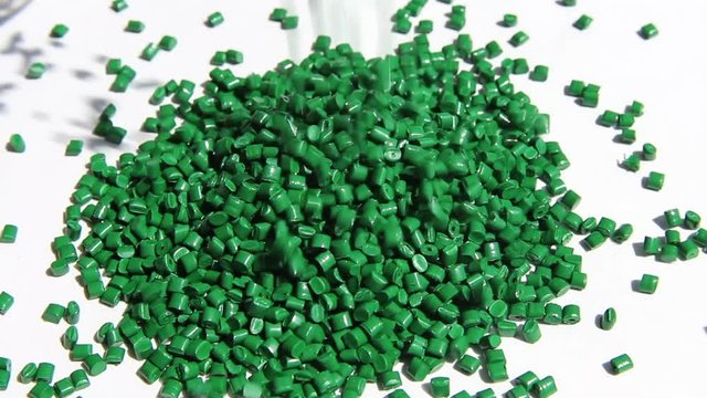 Plastic pellets . The dye granules for polypropylene polystyrene falling on a light background