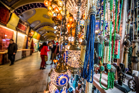 ISTANBUL, TURKEY- APRIL 17, 2017: Unidentified Tourists visiting and shopping in the Grand Bazaar in Istanbul. Interior of the Grand Bazaar with souvenirs on the foreground