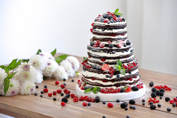 Wedding rustic naked cake with fruits on wooden background