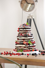 Wedding rustic naked cake with fruits on wooden background