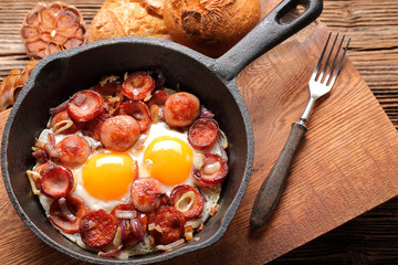 Cooked egg and sausages on frying pan